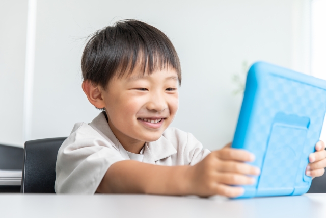 タブレットでプログラミングを学ぶ小学生の男の子